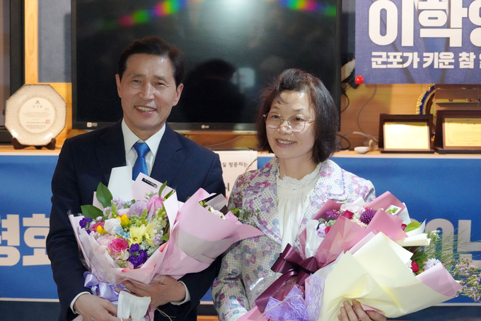 군포시 이학영후보 당선 확정후 부인과 함께 꽃다발을 받고 환하게 웃고 있는 모습