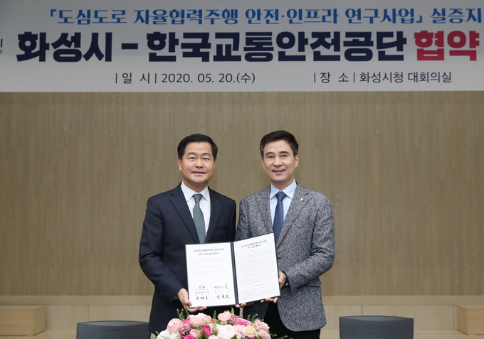 도심도로 자율협력주행 안전인프라 연구’실증사업을 위한 업무협약식 후기념 사진, 우측 서철모화성시장 , 좌측 권병윤 한국교통안전공단 이사장 모습