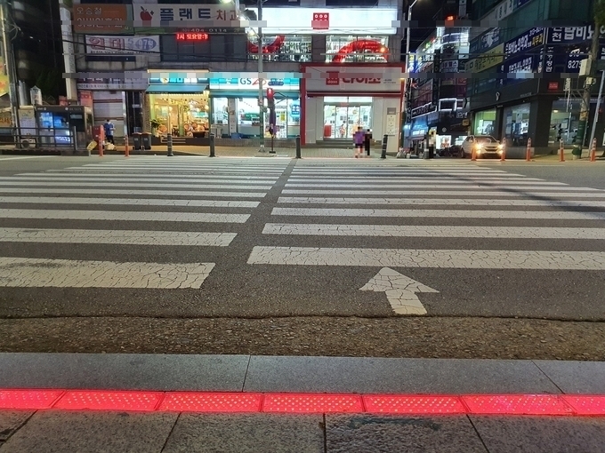 신호대기 중인 보행자들이 발밑에서 신호등의 색깔을 확인할 수 있다.