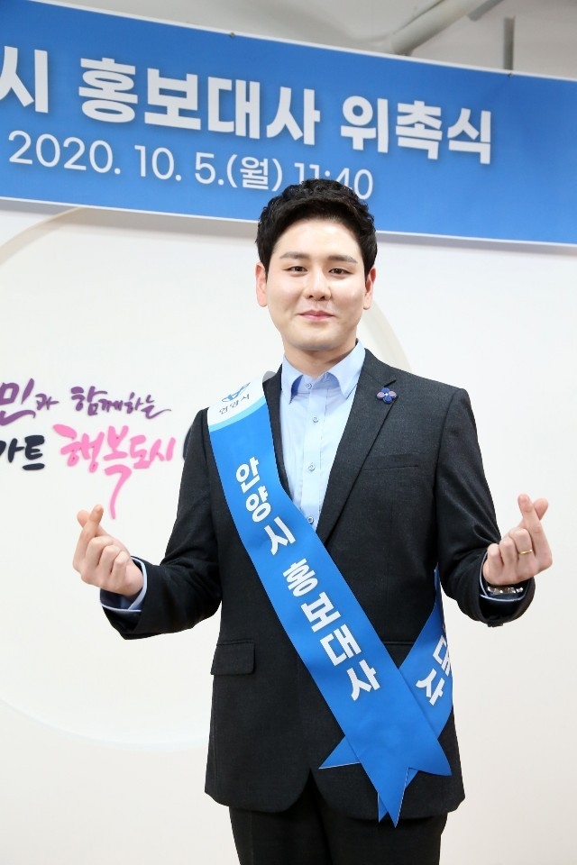 안양의 아들이라고 자부하는 보이스트롯 우승자, 박세욱 안양 홍보대사로 위촉 후 사랑의 표시를 하며 환하게 웃고 있다.