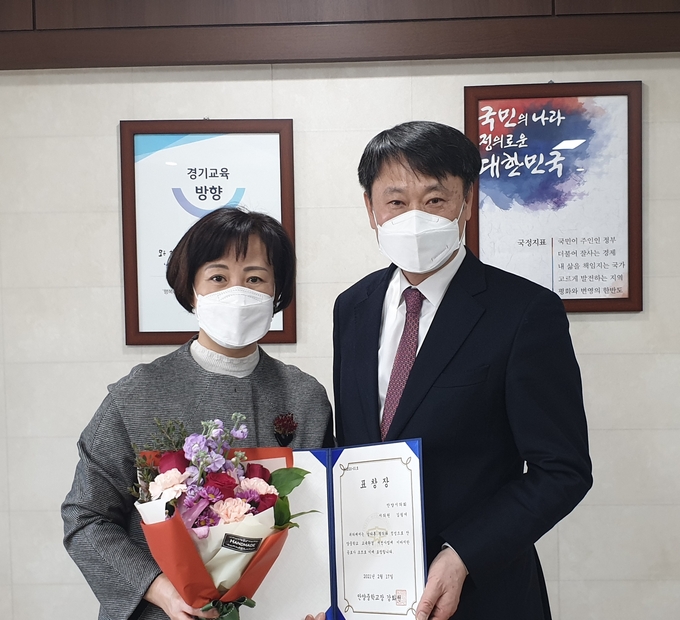 안양중학교 강화천 교장으로부터 안양중학교 교육환경 개선사업에 이바지한 공로를 인정받아 표창장을 수여 받고 있는 , 김필여 시의원 모습