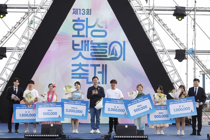 지닌 9일부터 시작된 제13회 뱃놀이 축제에서 입상한 바람의 사신단 수상자들과 기념 사진 , 가운데 정명근 화성시장 모습