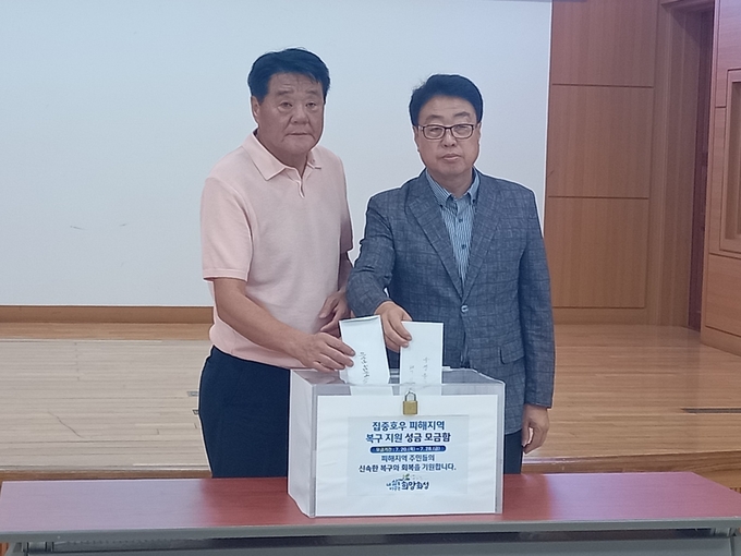집중 호우로 피해를 입은 수재이재민 돕기 모금함에 성금을 넣은 모습 , 우측 백진현우정읍장, 좌측 우정읍 사회단체 한춘택 회장