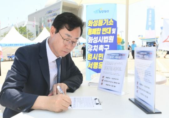 정명근 화성시장 , 등기소 통·폐합 반대 및 화성시 법원 유치촉구 범시민운동을 벌이면서 , 제13회 화성시 뱃놀이 축제기간에 마련된 부스에서 서명을 하고 있는 모습