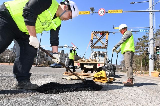 시민들의 안전을 확보하기 위해 수원시가 운영하고 있는 ‘포트홀 25시 기동대응반’ 작업자들이 도로에 발생한 포트홀을 긴급히 보수하고 있다.