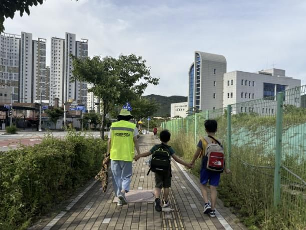 어린이 보행안전지도사가 초등학생들의 등하교를 돕고 있다.
