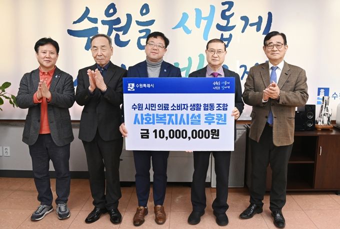 김현수 수원시 제1부시장(가운데)과 참석자들이 기부금 전달식 후 기념촬영을 하고 있다.